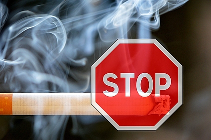 Stop-Schild über qualmender Zigarette
